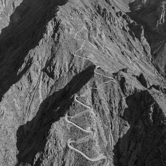 An aerial view of a hiking trail switchbacking up a steep mountain face